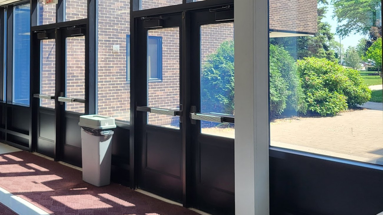 School entrance vestibule doors and sidelights treated with clear security film and a black structural silicone attachment by AAA Glass Tint.