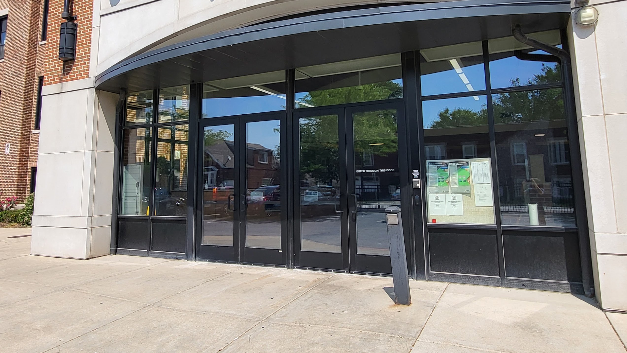 Aluminum storefront school entrance doors and sidelights treated with 8 mil clear security film and a Dow 995 structural silicone attachment by AAA Glass Tint.