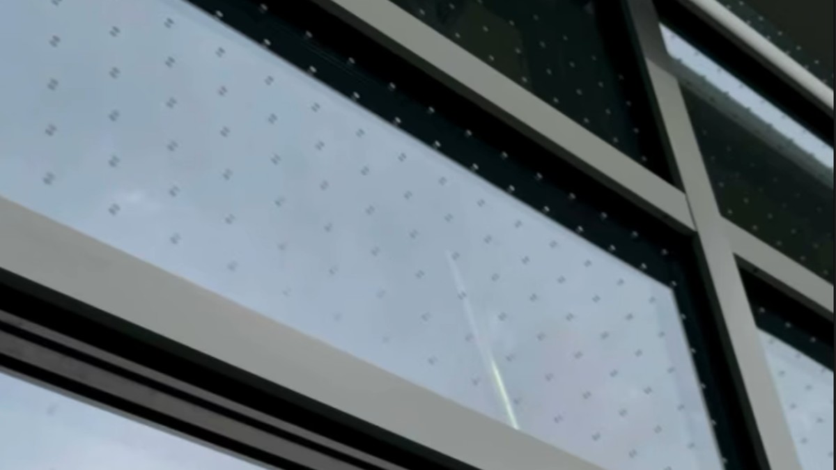 Solar Gard WingSafe bird collision film with a dot pattern applied to the exterior of commercial glass, seen against the sky.