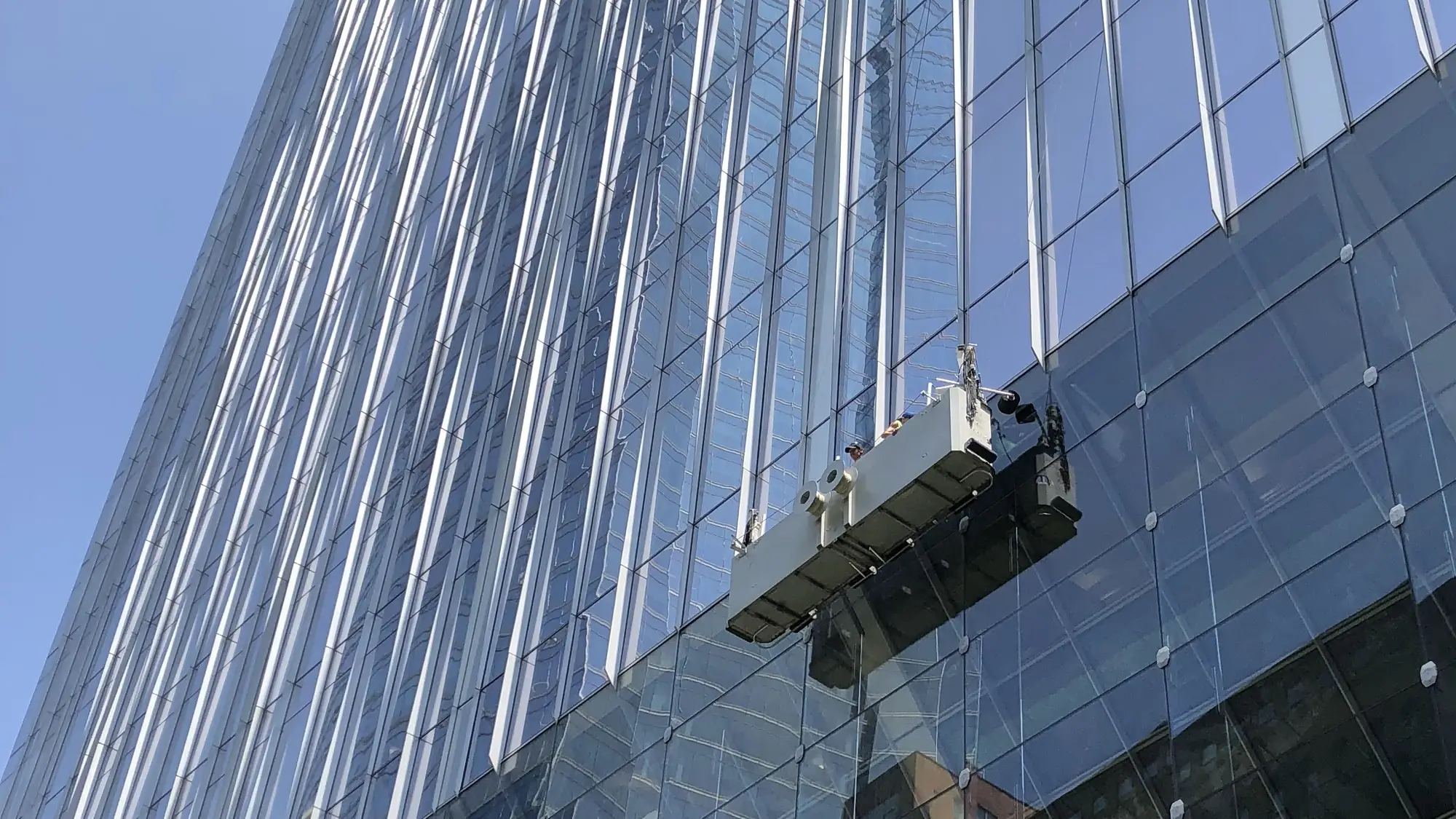 Suspended work platform at the glass curtain wall of a downtown Chicago office tower.