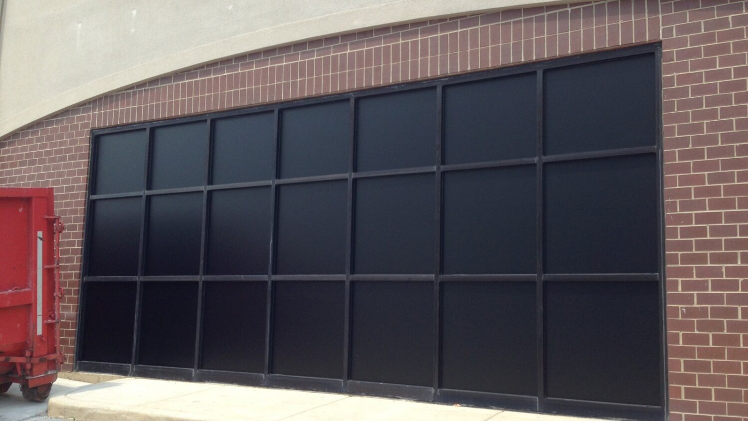 Large storefront opening in a brick building covered with black blackout window film installed by AAA Glass Tint.