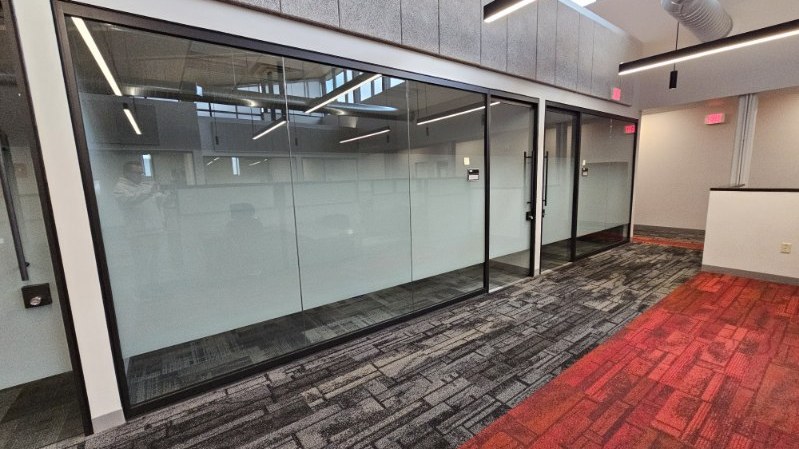 Glass office walls with frosted privacy film installed by AAA Glass Tint, screening the rooms from the corridor.